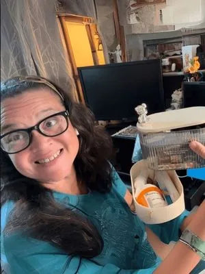 Person holding a charger organizer with a white lid and orange component, indoors.