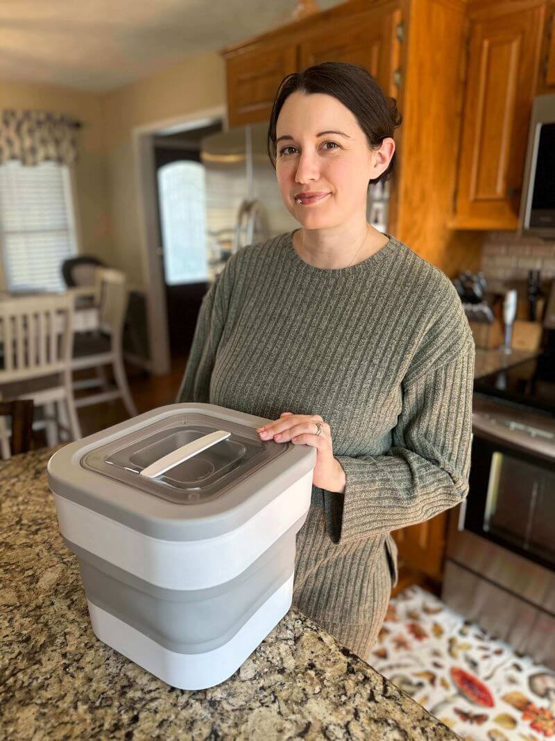 Woman holding a collapsible container in a kitchen