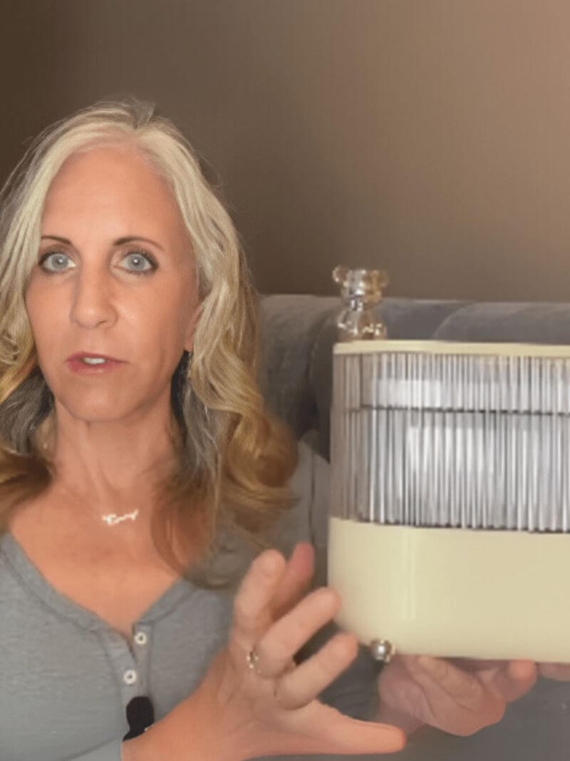 Woman holding a make up organizer in front of a brown wall