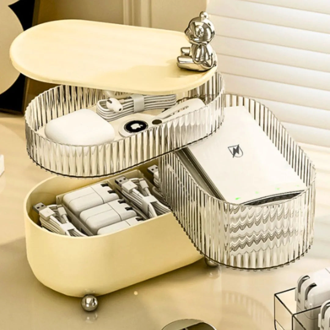 Beige and silver multi-layered organizer with electronic items on a light surface.